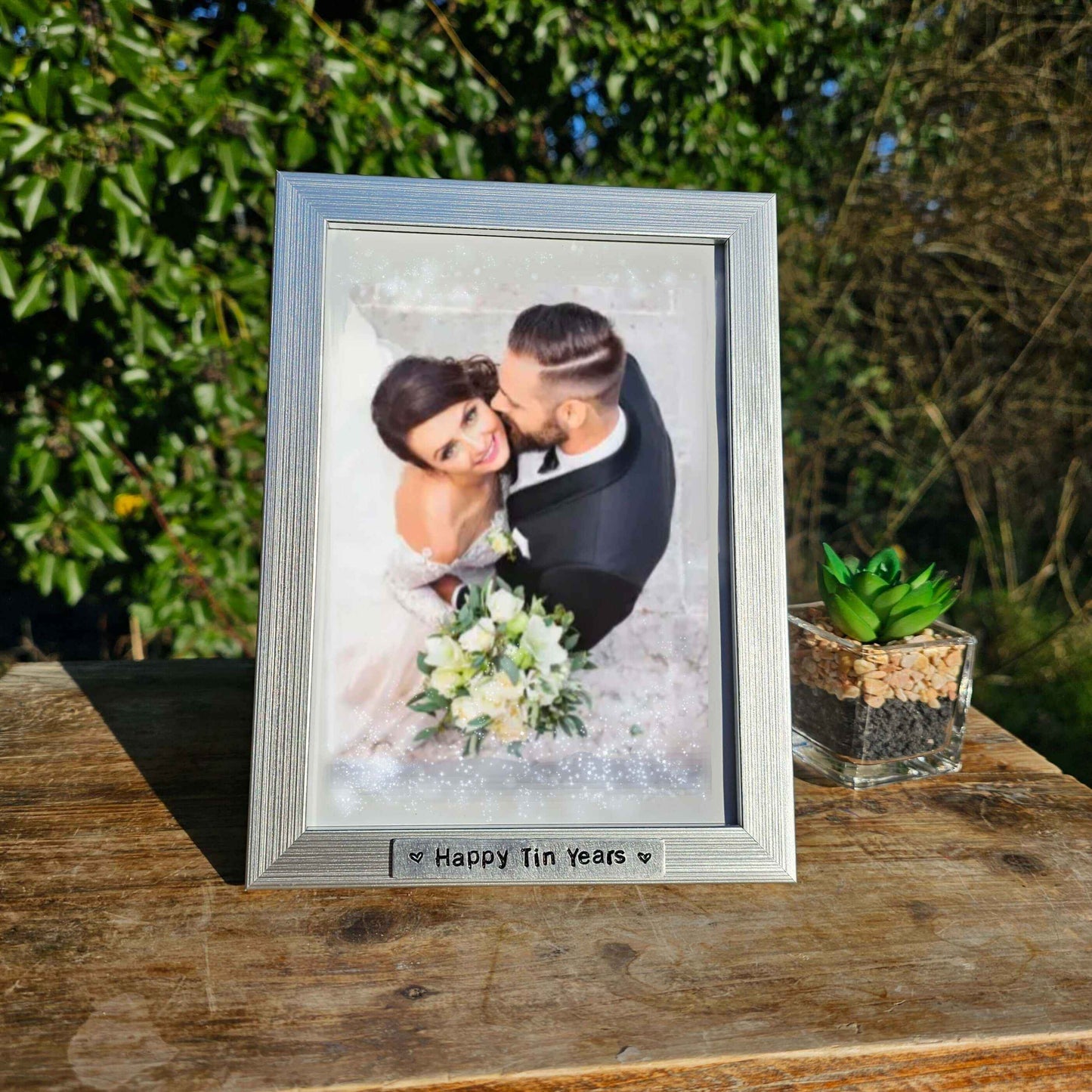 Tin Anniversary gift Photo Frame displaying a wedding picture titled 'Happy Tin Years' with a succulent next to it.
