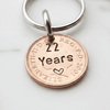 Keychain with a copper coin featuring '22 Years' engraved on a white background