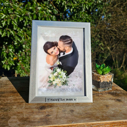 Tin Anniversary gift Photo Frame displaying a wedding picture titled 'Happy Tin Years' with a succulent next to it.